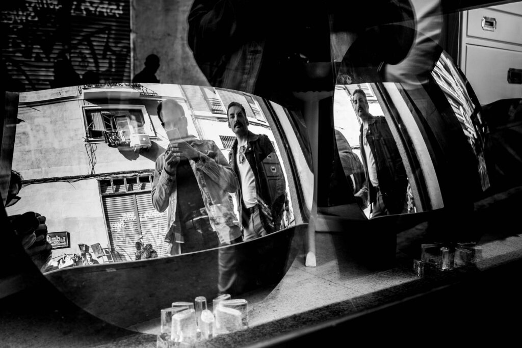 Fotografía callejera en blanco y negro de reflejos en espejos del Rastro de Madrid por Israel Quesada.